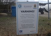 Brottsförebyggande skylt. ”Varning! Alla värdeföremål i detta område är stöldskyddsmärkta med DNA + mikropunkter”, står det på inhägnaden till båtklubben. Texten följs av översättning till engelska och ryska.  